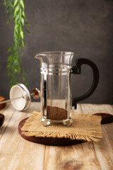 Empty french press pot coffee maker on rustic wooden table and gray background, also known as a piston coffee maker, or French press coffee maker, a simple device for preparing hot coffee.