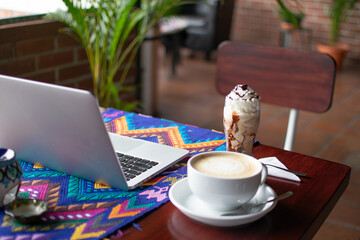 Photograph of a smoothie cocktail with chocolate ice cream and a large cup of coffee next to a...
