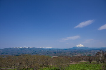 牧場から見渡す残雪のニセコ連峰や羊蹄山のパノラマ風景