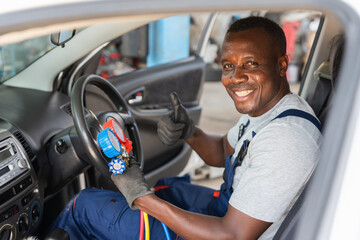 Rear view of Smiling Mechanic in Car Holding AC Gauges, Happy Auto Technician Giving Thumbs Up, Professional Car Repair Service Completed Successfully