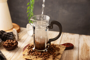 Pouring hot water in a French press..French press, also known as a piston coffee maker or French coffeemaker, is a simple device for preparing hot coffee.
