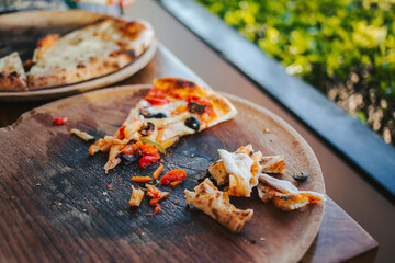 Last slice of delicious pizza and crispy crusts on a wooden delivery.