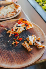 Last slice of delicious pizza and crispy crusts on a wooden delivery.
