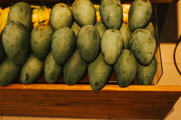 Large green mango on the counter in a supermarket. Exotic fruits in a fruit shop