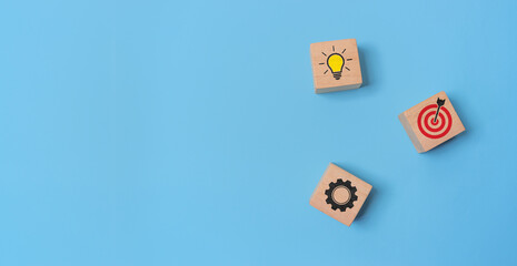 Creative idea, strategy, and goal achievement concept. Wooden blocks with lightbulb, gear, and...