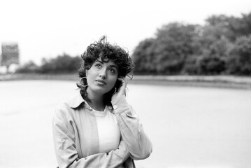 Young woman posing by the river in grainy black and white analog photo