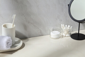 White towel, cotton buds, and grooming tools placed on a marble counter with soft stone background. A peaceful and minimal setup for self-care and bathroom visuals.