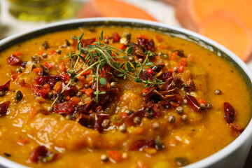 Sweet potato puree with spices in bowl on light background, close up