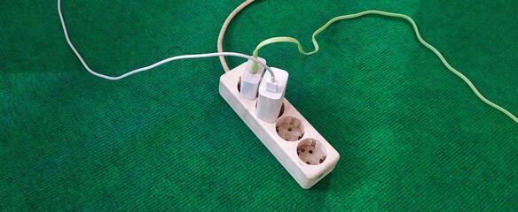 Fototapeta premium photo of handphone charger with data cable plugged into a socket, socket with cellphone charger, white socket, 4 socket