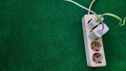 photo of handphone charger with data cable plugged into a socket, socket with cellphone charger, white socket, 4 socket