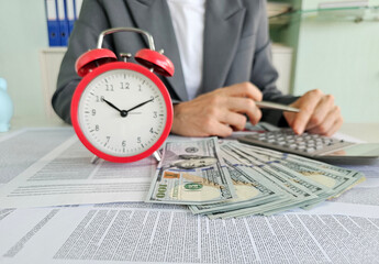 Time management and financial calculation in a busy work environment with cash and calculator...