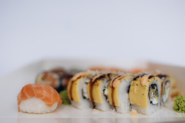 Assorted Sushi Rolls with Distinctive Toppings Presented on a White Plate