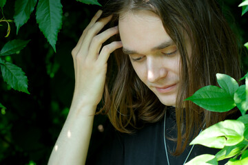 Young man reflects in serene green foliage