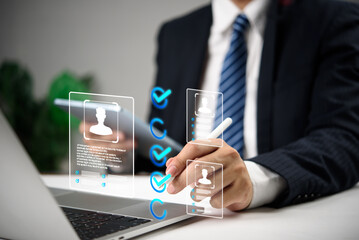 Businessman using digital interface to select candidates with virtual profile icons and checkmarks, representing modern recruitment, HR human resources technology, and hiring process.