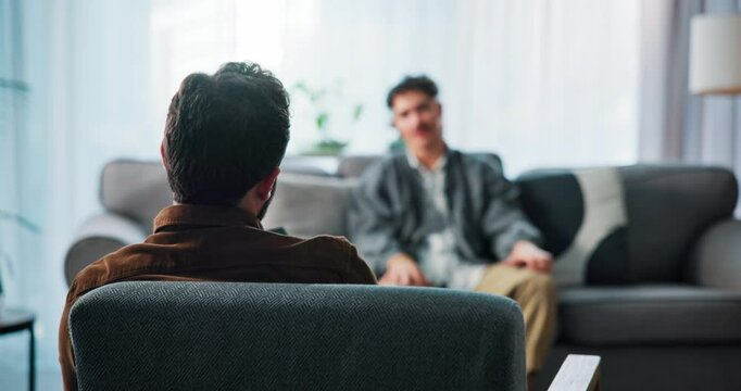 Back, talking and man on sofa with therapist for consulting, counseling and therapy session. Psychology, mental health and psychologist with patient for emotional support, advice and help in office