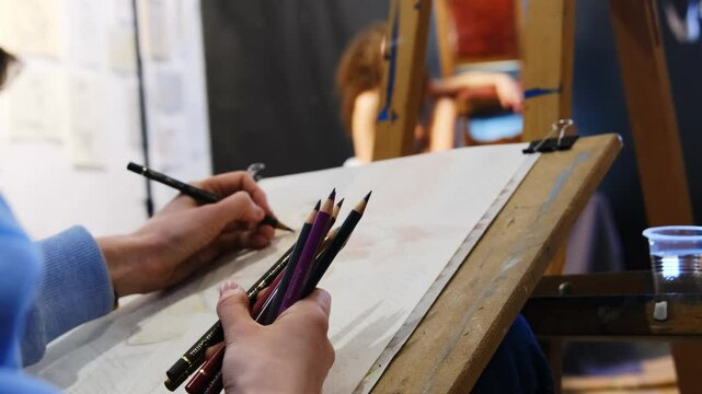 Creator draws picture of mannequin on sheet working in studio. Student completes special task and hones skills duiring lesson using pencil technique