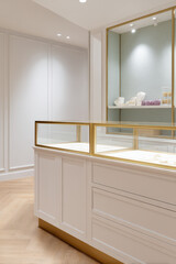 A luxury jewelry boutique with elegant glass display showcases sparkling jewels and a minimalist design in a well-lit, modern interior
