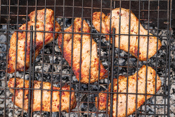 Succulent grilled chicken breasts sizzle over hot coals, evoking summer barbecues