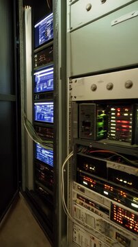 Data center server rack with equipment, switches, and wiring, featuring an old computer display, providing information technology, and technology infrastructure.