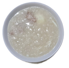 Chinese style minced pork porridge with soft boil egg on top for breakfast isolated on white background 