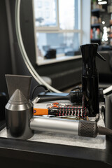 Professional hairdressing tools on salon counter with mirror reflection