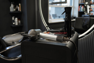 Modern hair salon equipment on countertop: hairdryers and styling tools