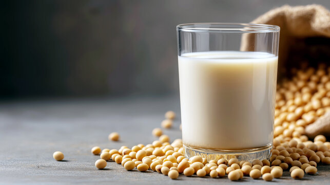 A refreshing healthy soy drink served in a modern glass, surrounded by raw soybeans, showcasing simplicity and nutrition on a light surface