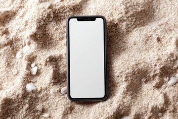 A modern smartphone with a blank white screen lies on sandy ground surrounded by small stones. Useful for vacation, lost phone, tech on the beach, or app mockup concepts.