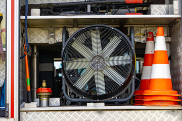 Rescue equipment inside a fire truck compartment – visible large smoke ventilation fan, traffic...