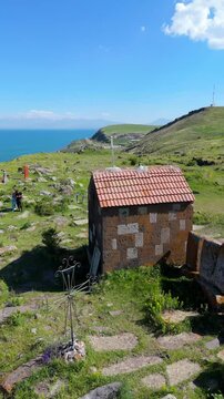 A small Church on top of a mountain. St. Hovhannes Church in Sevan taken with drone