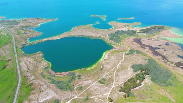 Aerial view of a tropical island with white sand beaches and volcanic features, captured by drone. Chayeri Island, Sevan, Armenia 
