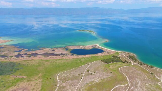 Aerial view of a tropical island with white sand beaches and volcanic features, captured by drone. Chayeri Island, Sevan, Armenia 