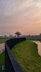 Fototapeta premium Serene Lakeside View with Curved Fence at Sunrise
