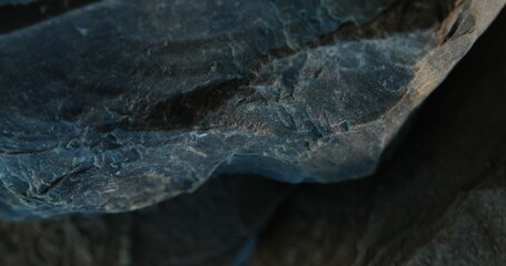 Close-up of dark slate rock with jagged edge and soft bluish shadows