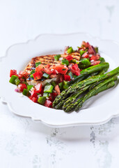 Grilled chicken fillet with asparagus and tomato salsa. Close up. 