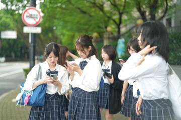 In early June in Pudong, Shanghai, seven Japanese high school girls in summer uniforms walk together down a city street, smiling and chatting as they head to school under the soft morning sunlight.