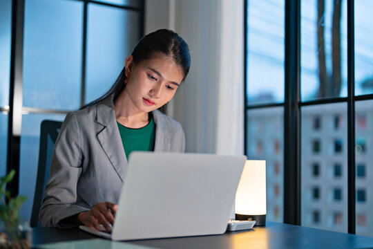 woman working with laptop late night at workplace