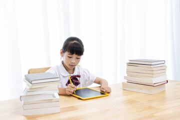 A Chinese little girl is drawing on a drawing board