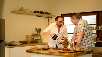 Senior man and son brewing fresh coffee together during a cozy morning at home. Father day concept