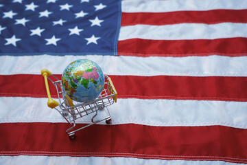 Shopping cart with globe on American flag symbolizing global business and politics