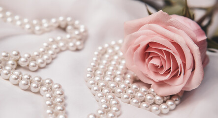 The branch of pink rose on white fabric background
