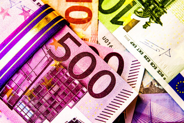 A pack of European currency lies on the background of the Euro