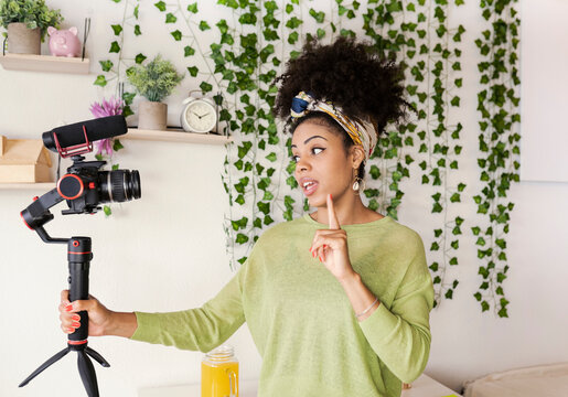 Young woman vlogging through camera at green house - Powered by Adobe