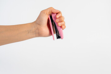 Pink stapler in hand on white background