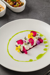 Colorful beetroot slices with goat cheese, garnished with edible flowers