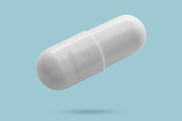 White medicine pill capsule float on blue background