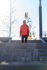Senior man walking down stairs in a sunny outdoor park