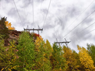 Krasnoyarsk Hydroelectric Power Station viewed through vibrant autumn foliage and power lines...