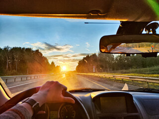 Traveler enjoys a scenic sunset drive through a picturesque landscape on a road adventure