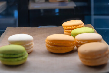 Vibrant Assortment Of French Macarons On Rustic Paper. Colorful French Macarons Displayed On Rustic Paper With A Variety Of Flavors.